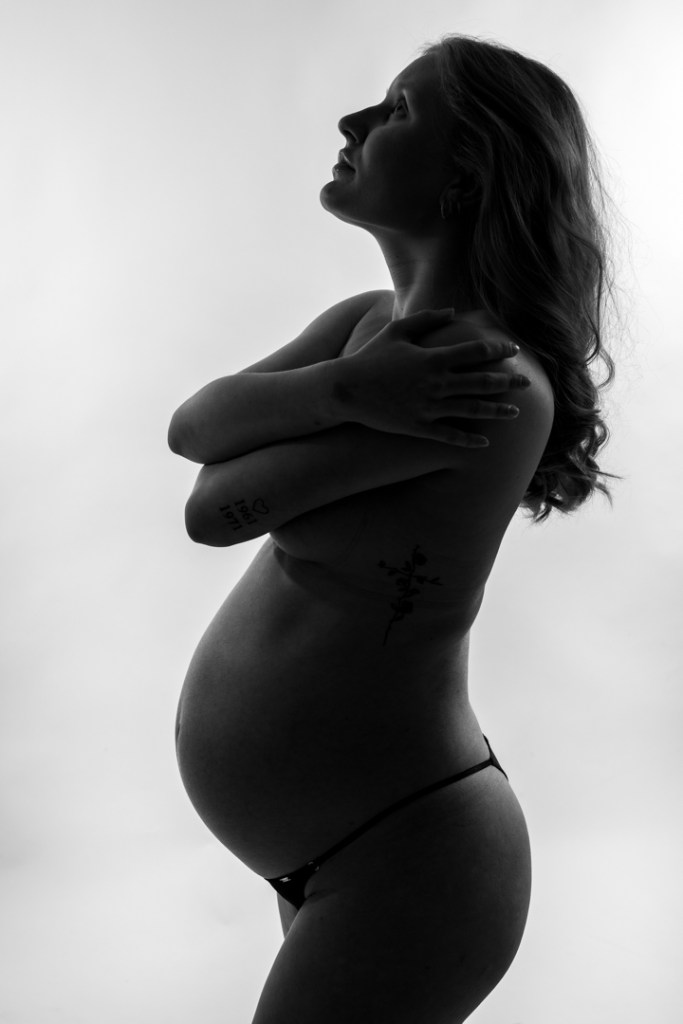 gravid kvinna i fotostudio, mest en siluett