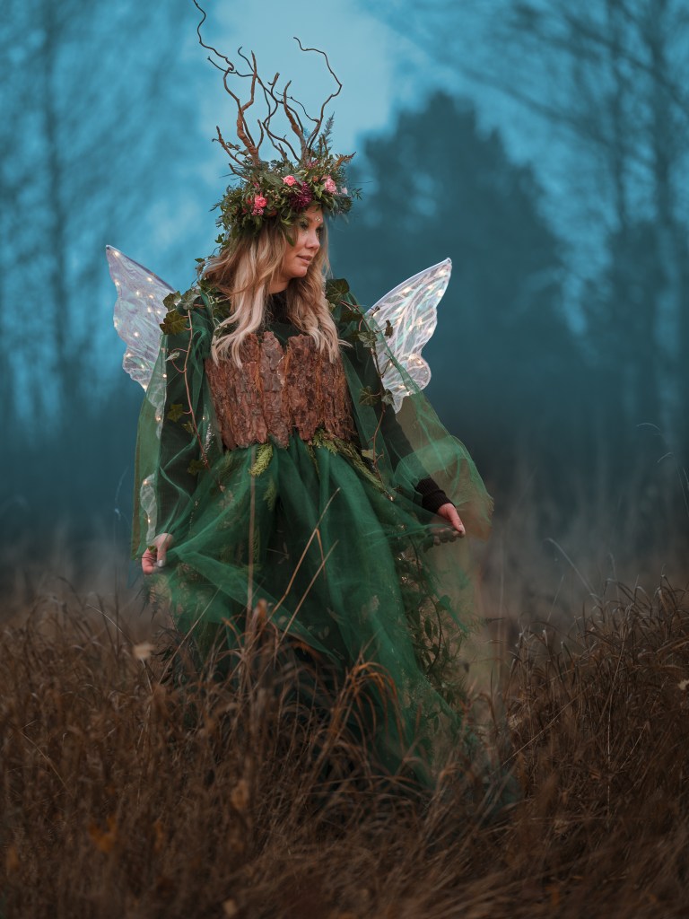 Kvinna i kläder gjorda av blommor, som ser ut som en älva