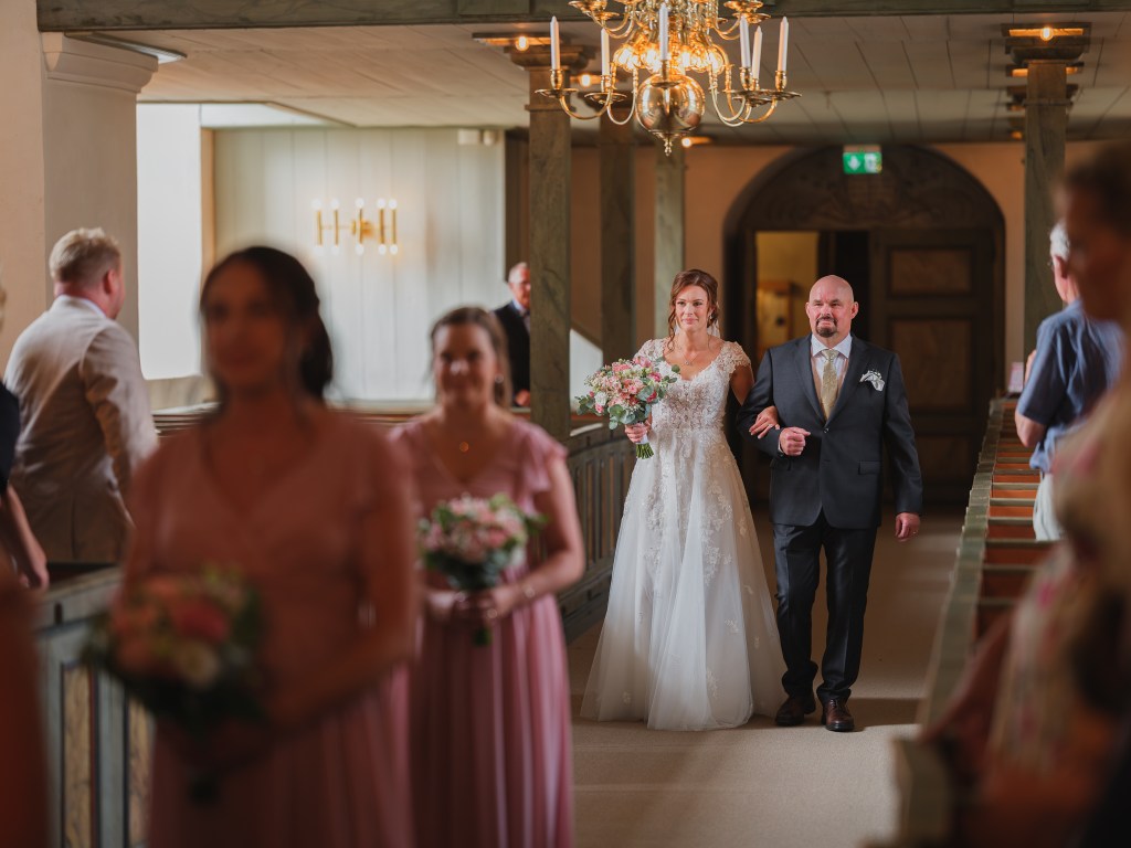 Bruden går in i kyrkan med sin pappa