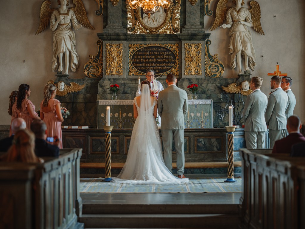 Brudparet står framme vid altaret i kyrkan