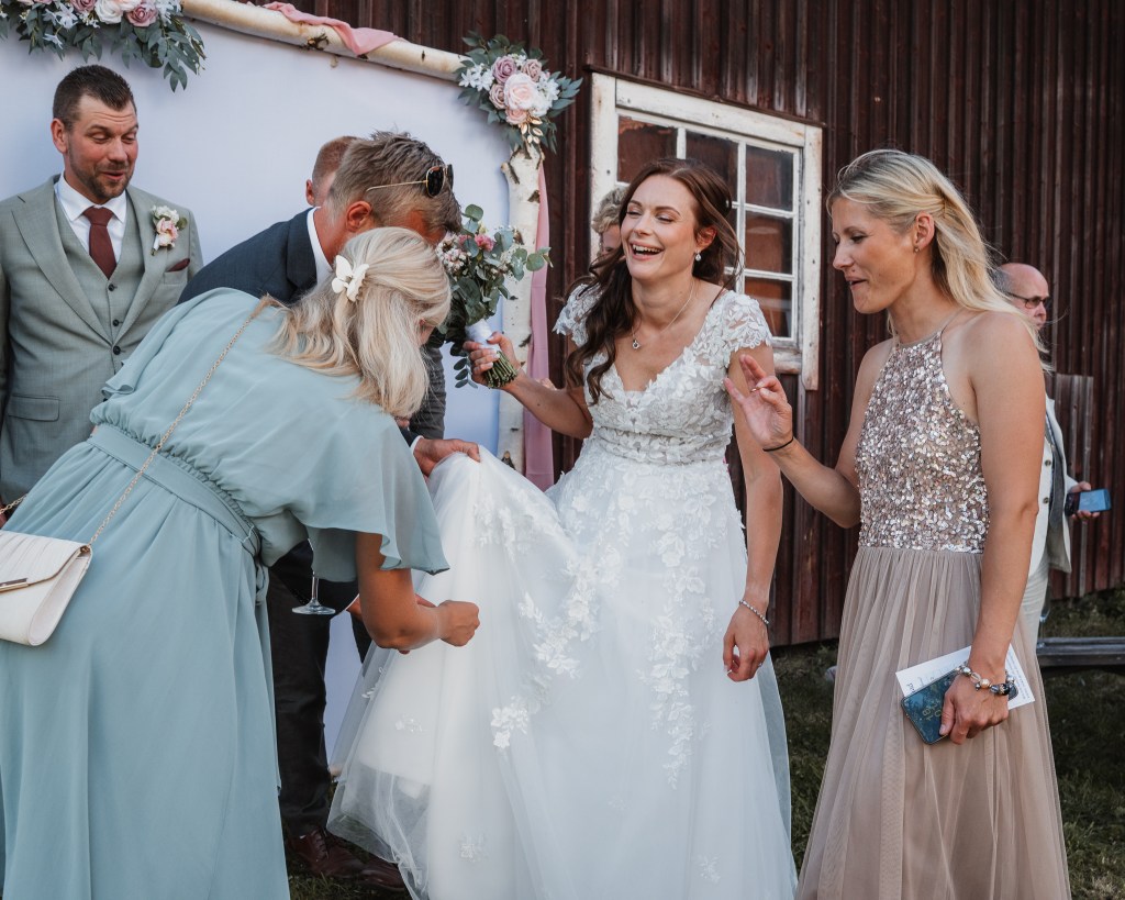 Bruden skratar med gäster på mingel