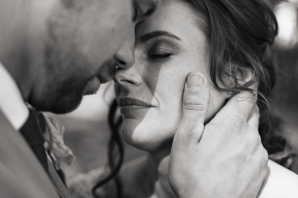 Svartvitt porträtt på brudparet panna mot panna väldigt känslosam