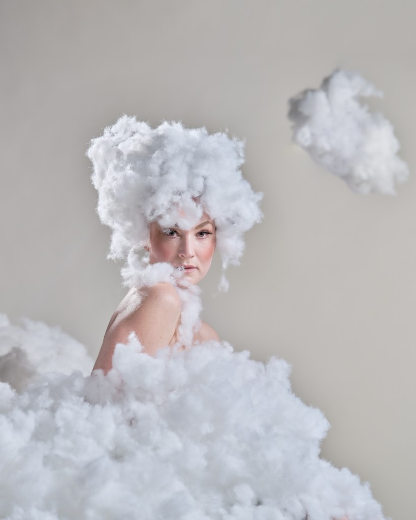 Kvinna som sitter i ett moln gjort av bomull