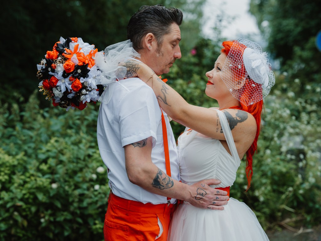 bruden och brudgummen håller om varnadra och tittar varandra i ögonen